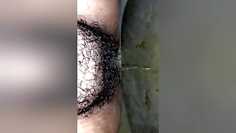Hairy darling pissing in the bathroom with her shaved hole